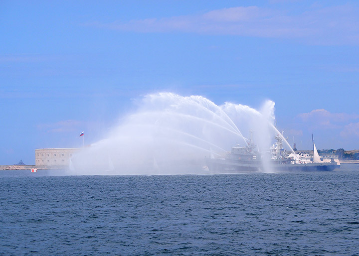 Противопожарное судно ПЖС-123 при помощи пожарных лафетов создает водяные фонтаны в бухте